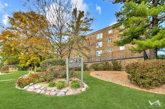 Front view of an apartment building with brick facade and multiple windows.