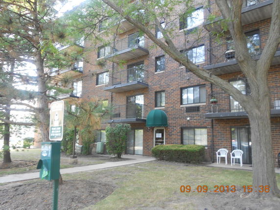 Front view of a multi-story apartment building with balconies.