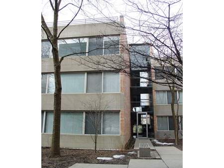 Front view of a multi-story building with large windows.
