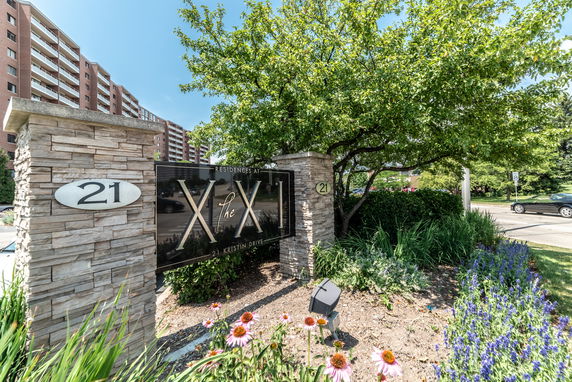 Front view of a multi-story residential building with a sign reading 'Residences at The XXI'.