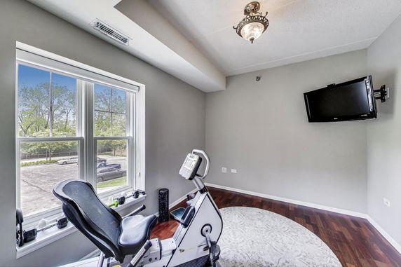 Room with exercise equipment and mounted TV.