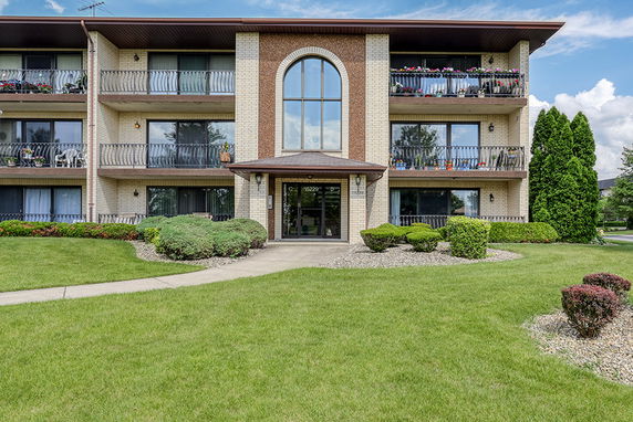 Front view of a three-story apartment building with balconies.