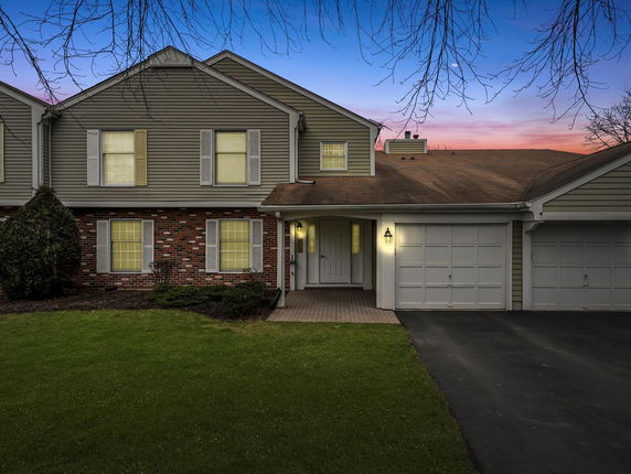 Front view of a two-story house with attached double garage and brick facade.
