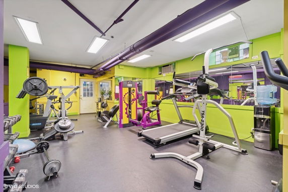 Indoor gym with various exercise equipment including treadmills and weight machines.