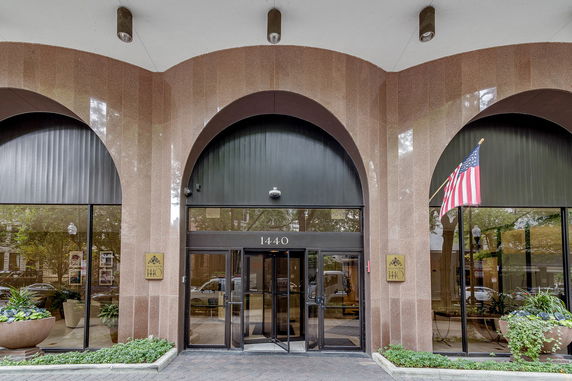 Front view of a building entrance with large archway windows and a glass door.