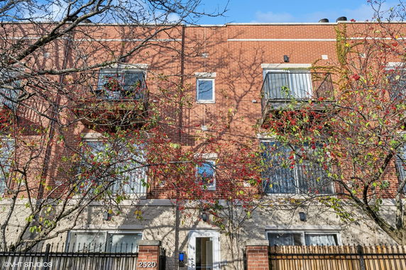 Front view of a multi-story brick building with balconies.