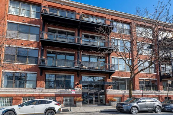 Front view of a multi-story brick building with balconies.