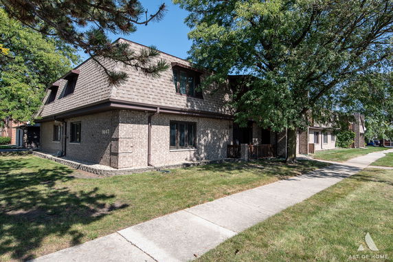 Front view of a two-story brick house with a sloped roof.