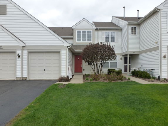 Front view of a white two-story house with a garage and a red front door.
