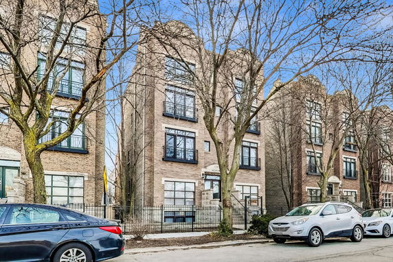Front view of a brick multi-story residential building with several windows.