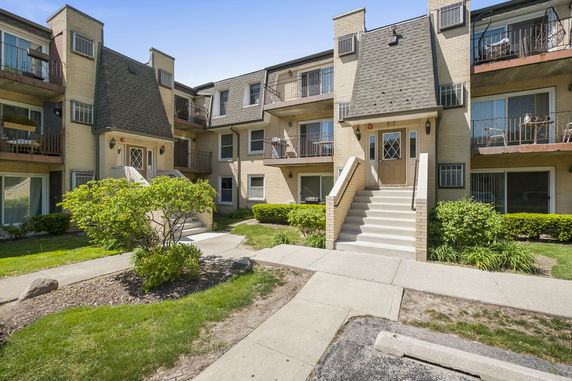 Front view of a multi-story building with exterior staircases and balconies.