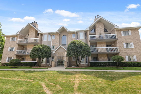 Front view of a multi-story apartment building with balconies.