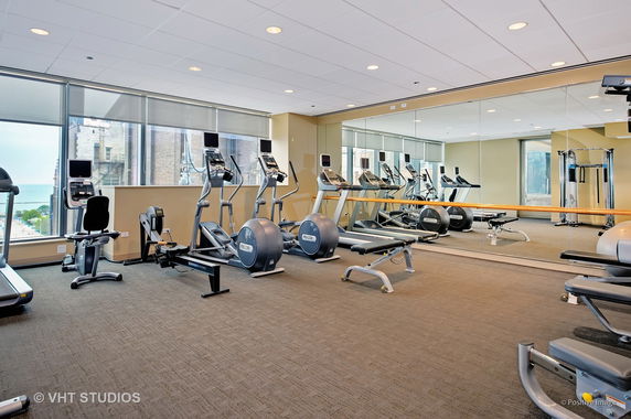 Indoor gym with exercise equipment and large mirrors