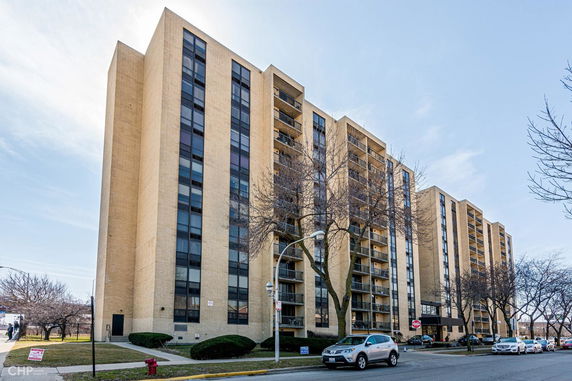 Front view of a multi-story apartment building with balconies.