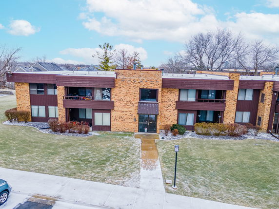 Front view of a two-story brick apartment building with balconies.