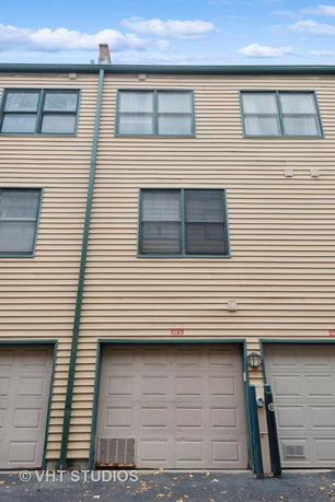 Front view of a multi-story building with garages on the ground floor.