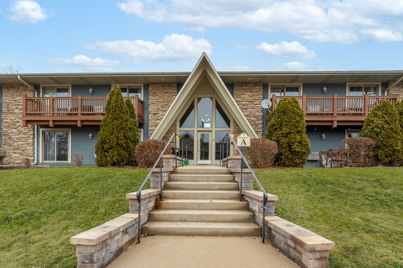 Front view of a two-story building with a central A-frame entrance and balconies.