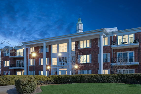 Front view of a multi-story building with balconies and columns.