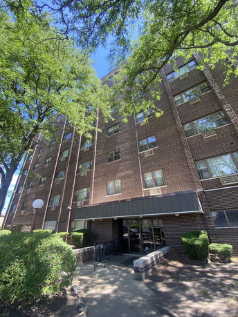 Front view of a multi-story brick apartment building.