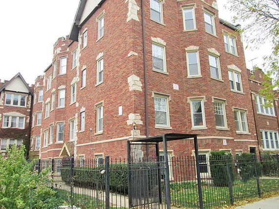 Front view of a multi-story brick building with multiple windows.