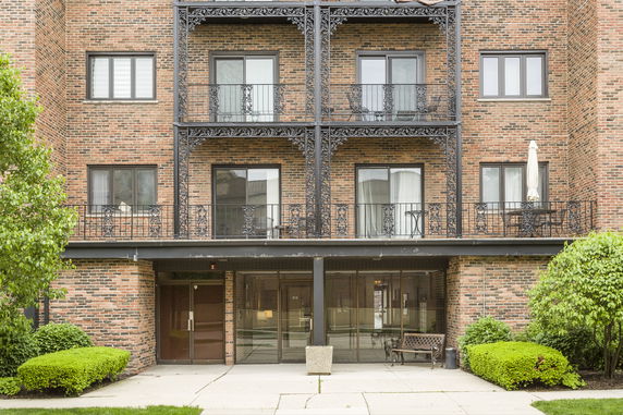 Front view of a brick apartment building with balconies.