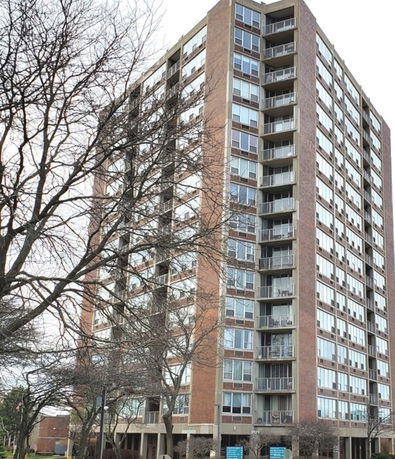 Front view of a multi-story apartment building with balconies.