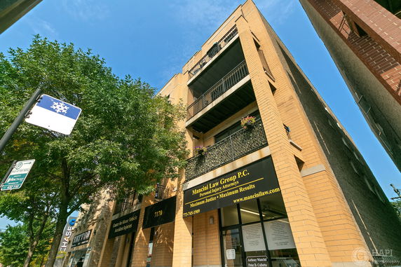 Front view of a multi-story building with balconies and a law firm on the ground floor.