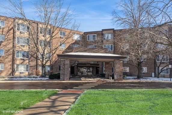 Front view of a multi-story brick building with a covered entrance.