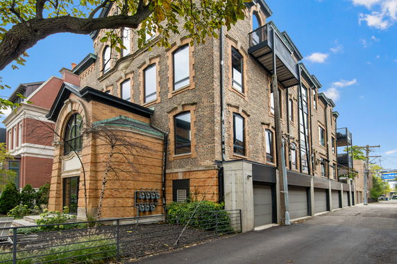Front view of a multi-story brick building with large windows and garage entrances.