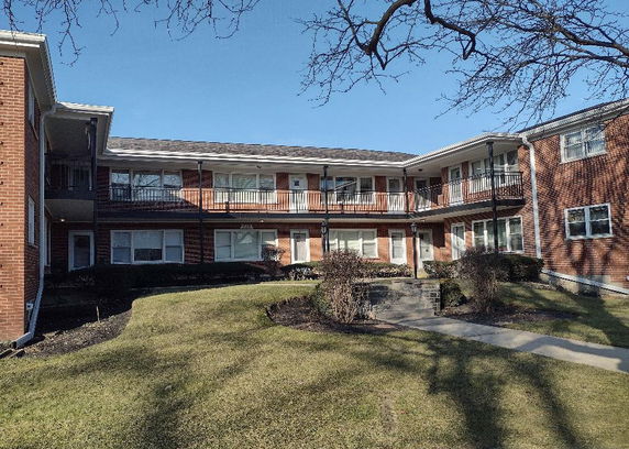 Front view of a two-story brick apartment building.