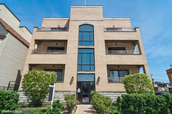 Front view of a multi-story brick building with balconies.