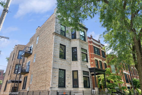 Front view of a multi-story brick building with multiple balconies.