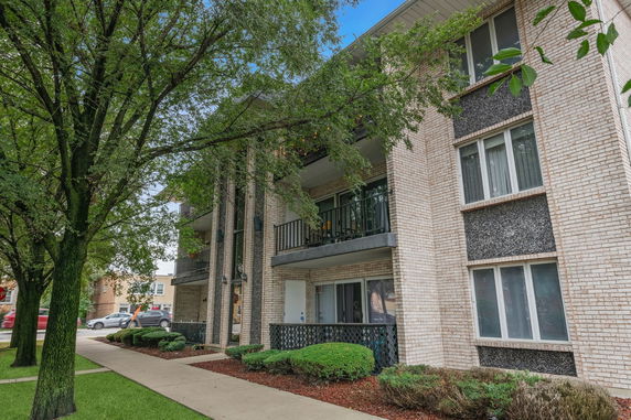 Front view of a multi-story apartment building with balconies.