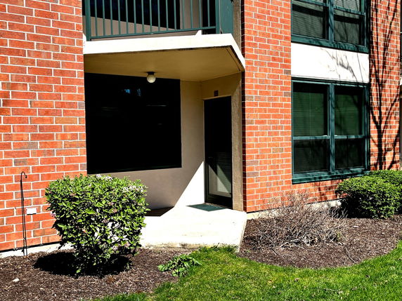 Front view of a building with red brick exterior and black-framed windows.