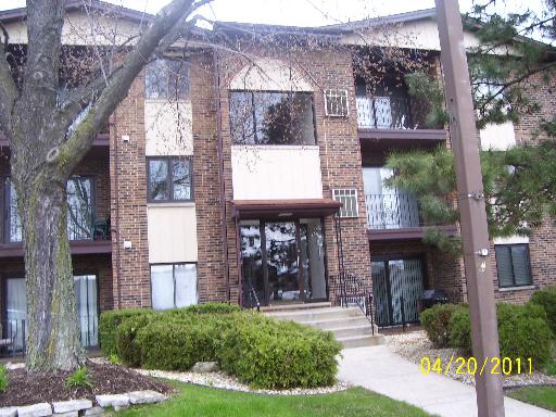 Front view of a multi-story brick apartment building with balconies.