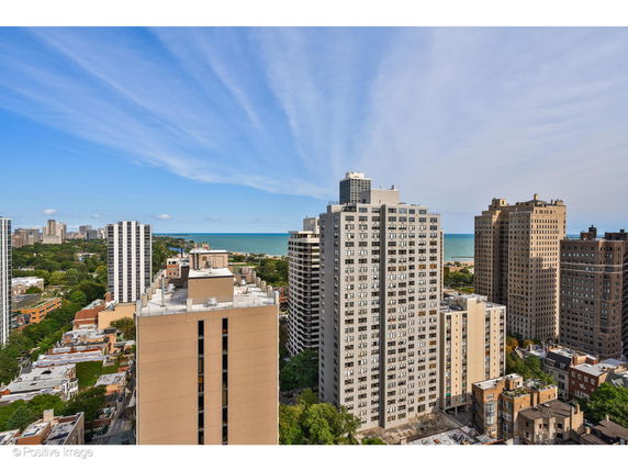 Panoramic view of city buildings with a body of water in the background.