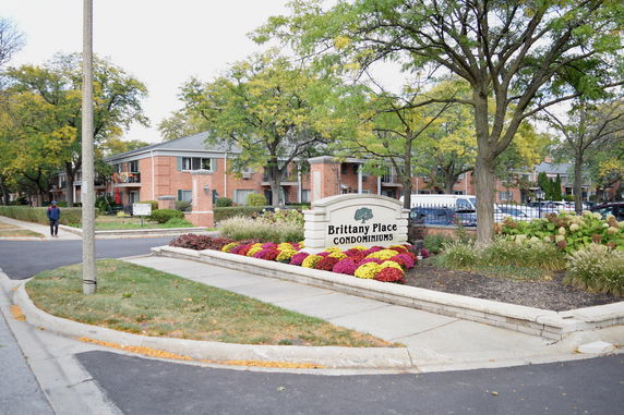Front view of a condominium complex with signage and landscaped entrance.