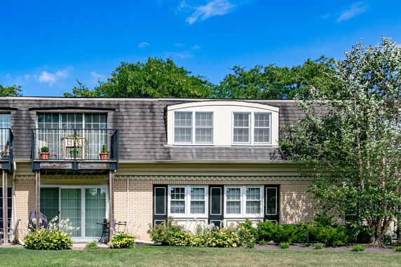 Front view of a two-story house with balconies and a brick exterior.
