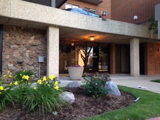 Front view of a building entrance with stone accents and concrete pillars.