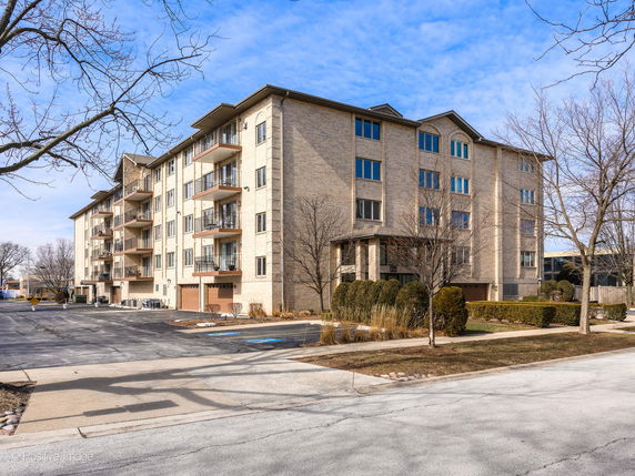 Front view of a multi-story apartment building with multiple balconies.