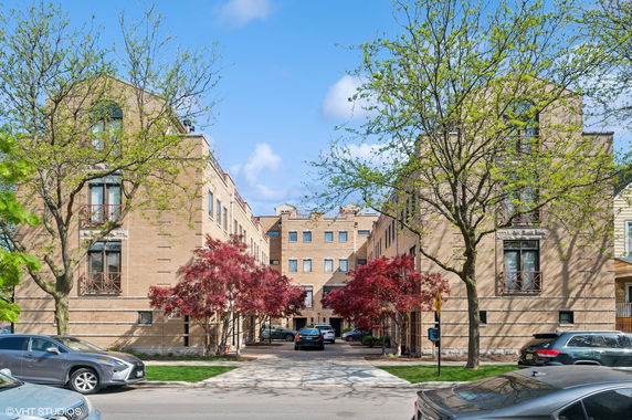 Front view of an apartment building with multiple levels and a central entrance.