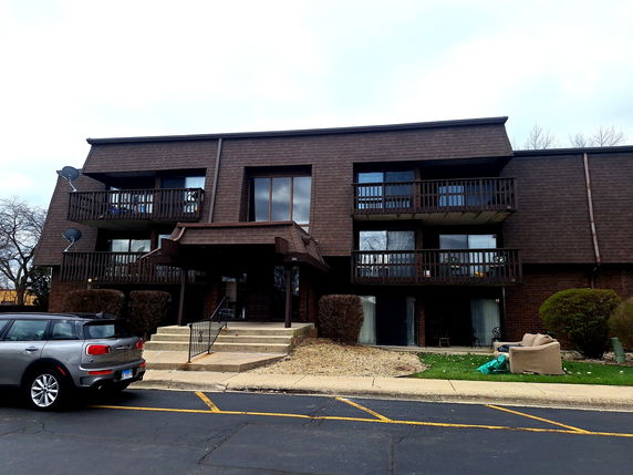 Front view of a two-story apartment building with balconies.