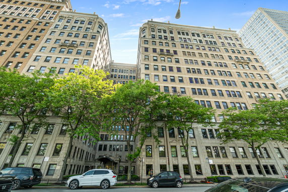 Front view of a multi-story building with large windows and decorative architectural details.