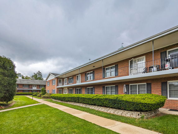 Front view of a two-story brick apartment building with balconies.