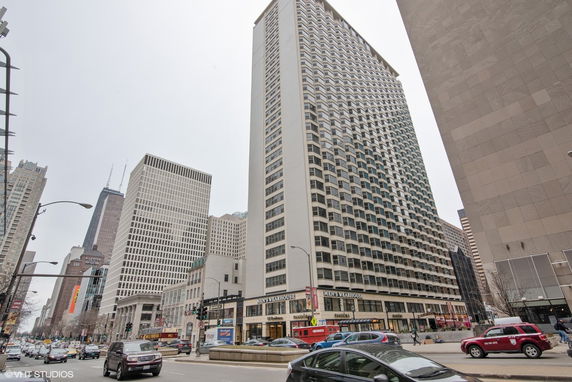 Front view of a tall, multi-story skyscraper in an urban setting.