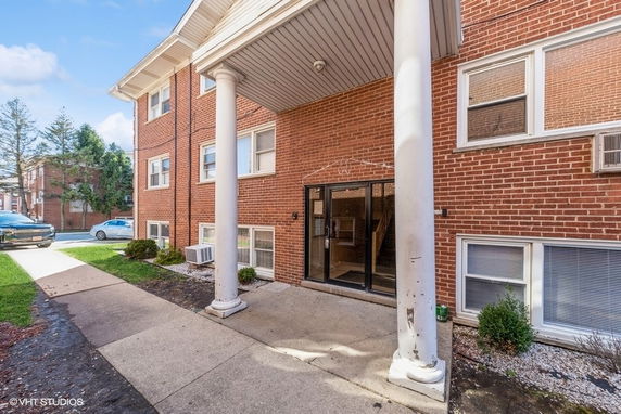 Front view of a brick residential building with a columned entrance.