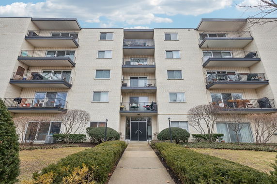 Front view of a multi-story apartment building with balconies.