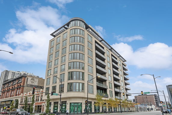 Front view of a multi-story modern building with large windows and balconies.