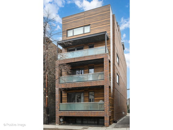 Front view of a multi-story building with glass balconies and a modern design.