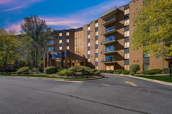 Front view of a multi-story apartment building with balconies.